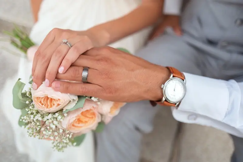 hands holding a wedding invitation suite, styled with calligraphy and floral accents